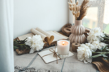 Naklejka na ściany i meble Burning candle and white peonies, vintage aesthetic