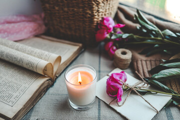 Burning candle and pink peonies, vintage aesthetic