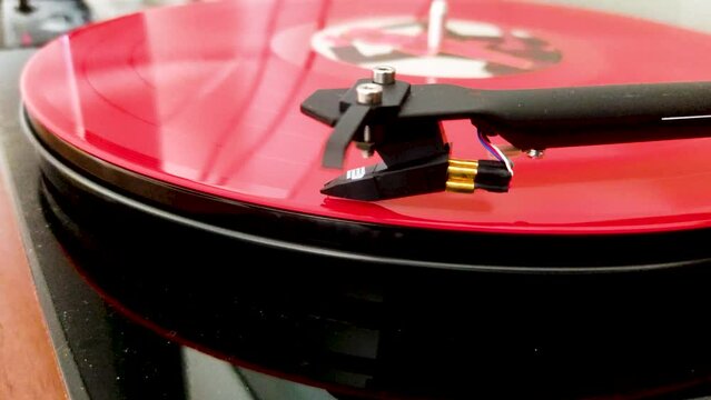 Retro Turntable System Playing a  Red Vinyl Record. Stylus Needle on the Vintage Spinning Vinyl LP. 4K Video Footage.