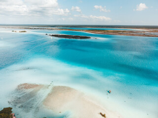 Drone shot showing a large blue fresh water lagoon in Bacalar, Mexico.