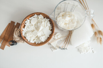 Wooden bowl with soy wax and wooden wicks close-up, candle making