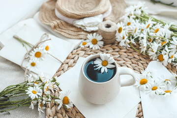 Obraz na płótnie Canvas Vintage still life on the windowsill, a cup of tea and a bouquet of daisies