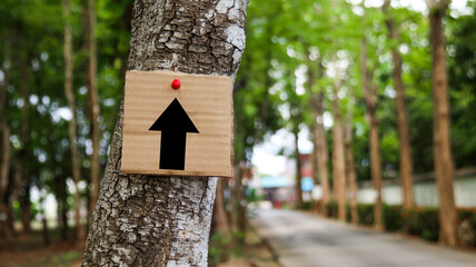 Paper board sign with graphic of directional arrow with blurred background