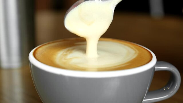 Stirring thick foam cappuccino with spoon. Milk foam cappuccino, latte
