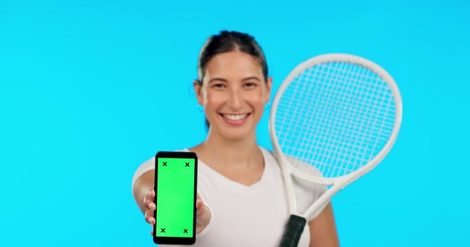 Phone, green screen and tennis with a woman on blue background in studio for sports marketing. Portrait, smile and fitness with a female athlete holding chromakey mockup on a mobile screen or display