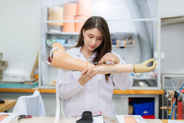 Technician holding prosthetic limb checking and working in laboratory