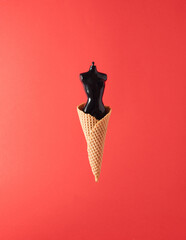 Black doll body ice cream on red background. Minimal art fantasy concept. Summer fairytale.