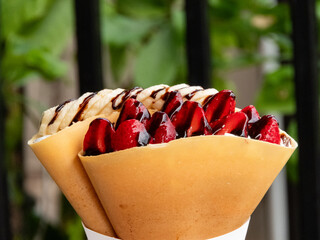 Crispy crepe filled with luscious strawberry whipped cream is a delightful treat that combines the satisfying crunch of the crepe with the light and creamy sweetness of the strawberry filling.close up