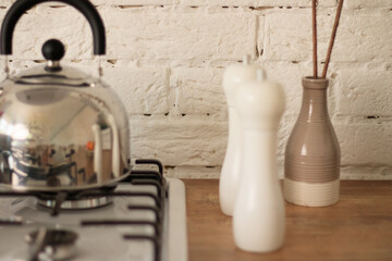 Kettle is heated on built-in gas hob in modern kitchen.
