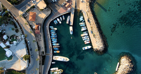 Drone shooting top view of the coast with harbor and small port with stylish yachts, beach and...