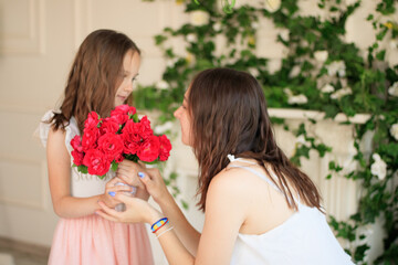 Happy mother's day. Child daughter congratulating her mother and giving her bouquet of flowers.