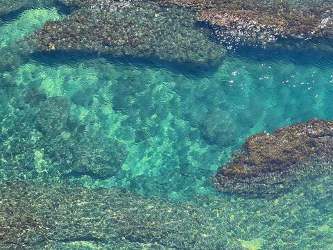 Sea water shiny turquoise blue surface and rocky coast aerial view beautiful seascape.