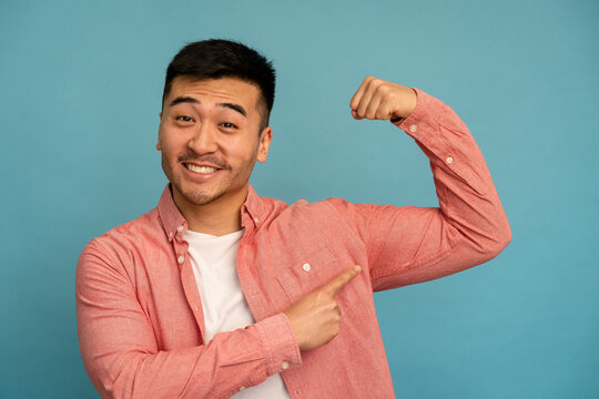 Smiling Asian Man Flexing His Arm.