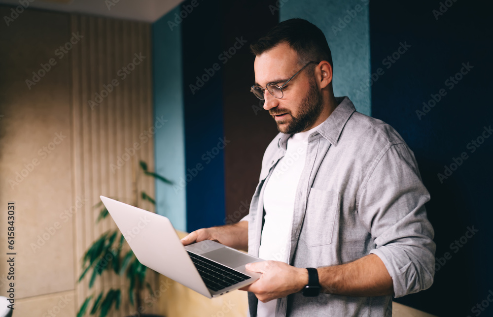 Aufkleber concentrated man working on netbook while standing in office