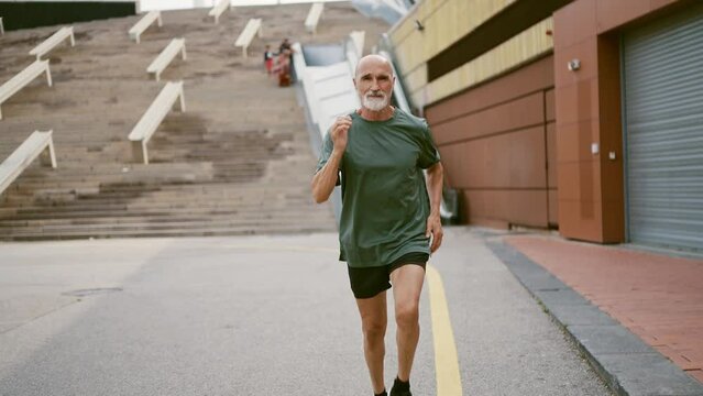 80 years old man making sport and different activities outdoor. Senior man training in the city. Concept about healthy lifestyle and seniority