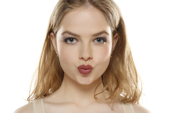 Portrait of attractive woman making kissing gesture on a white background