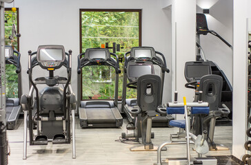 Modern light gym. Sports equipment in gym. Barbells of different weight on rack.