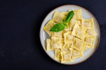 Tasty Appetizing Ravioli with Cheese and Basil on a Plate, Dark Background