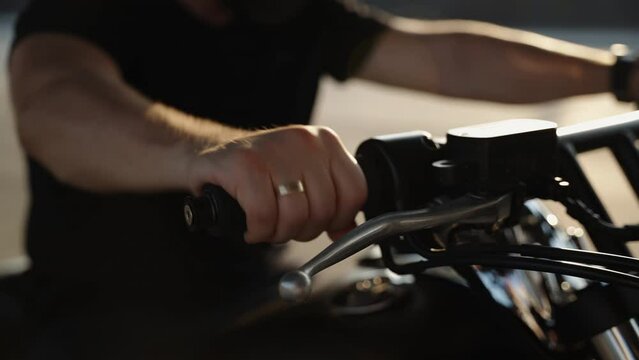 The throttle stick on the motorcycle. A man's hand twists the fuel supply drosel on the bike. Motorcycle detail. Summer hobbies on bikes.