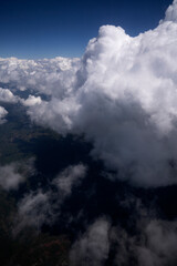 Cloudscape. Aerial view of the white clouds and green hills seen from above.