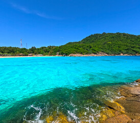 Kho Rasha island off the coast of phuket thailand by speed bias from Chalong Bay, beautiful turquoise Blue beach with white soft sand and lush green trees 