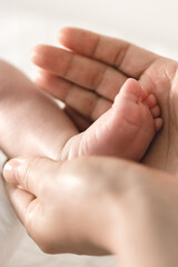 A baby's feet being hold by his father's hands