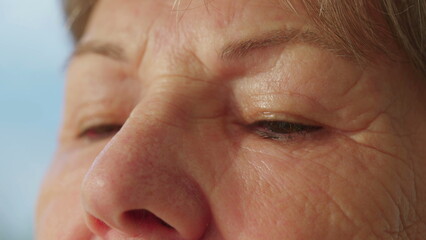 Pensive senior woman close-up eyes in deep reflection. Contemplative older lady eye_s detail