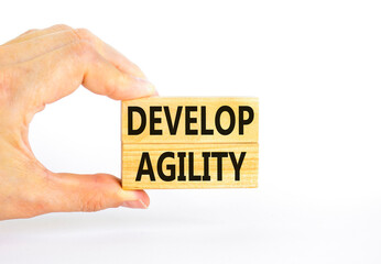 Develop agility symbol. Concept words Develop agility on wooden blocks on a beautiful white table white background. Businessman hand. Business, support and develop agility concept. Copy space.