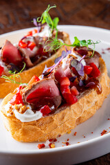 Strawberry bruschetta with duck meat, goat cheese on plate