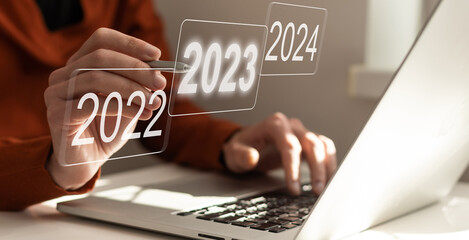 Businessman pointing to digital 2024 on virtual screen. Countdown to 2024 concept. Space for text....