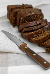 Sliced ​​black bread with seeds, knife