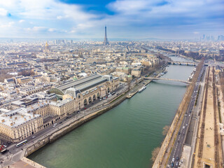 Aerial drone view of the Orsay Museum (Musée d'Orsay) on the Left Bank of the Seine, and the Eiffel Tower in the background, Paris, France
