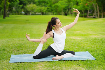 Pleasant millennial woman practice yoga outdoor in the morning during wellness retreat.