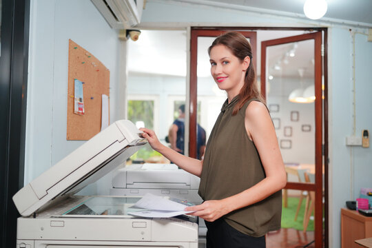 Young Woman Copying Document With Photocopy In Office. Officer copying document with copier machine
