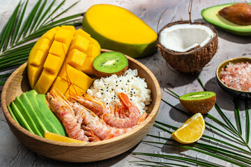 Poke with shrimp, avocado, rice, mango, kiwi and coconut. Hawaiian cuisine. Tropical food. Lunch on...