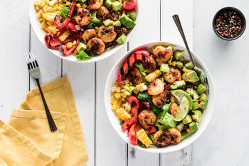 Cajun prawn bowls loaded with fresh vegetables, avocados and rice.