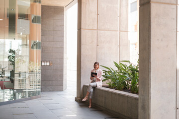 Young woman resting in her working hours using her smartphone. Concept: business, start up, financial zone