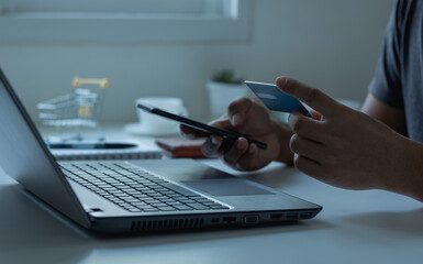 Fototapeta premium Online shopping concept. Customer makes a purchase on the Internet on a smartphone with a credit card, online payment, shopping online, e-commerce, internet banking, and spending money.