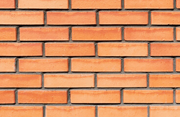 New red brick wall texture with cement straight seam lines. Flat straight bricks. Text space. Background closeup.