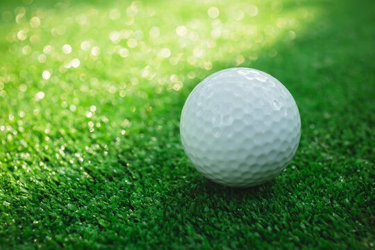 Golf ball with putter on green course. Image with selective focus