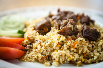 Uzbek pilaf with beef on a wooden background
