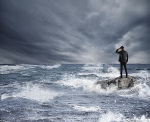 Businessman looking for the future during storm in the sea. Concept of economic crisis and problem in affairs