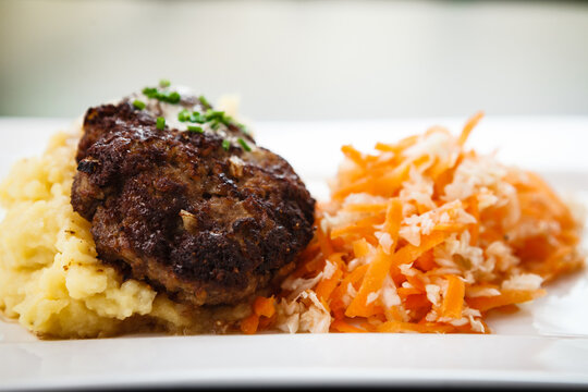 Minced beef cutlet with mashed potatoes in creamy sauce and carrot-cabbage salad