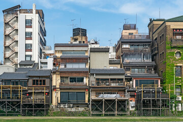 Japanese abstract urban background featuring details of chaotic vintage city buildings and urban skyline in summer day in Kyoto, Japan.   