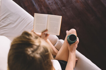 Unrecognizable woman with book and coffee