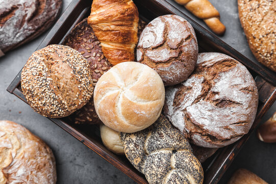 A basket full of delicious freshly baked bread on wooden background