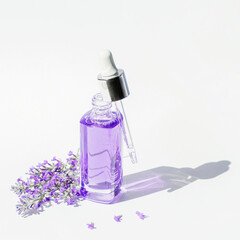 Lavender cosmetic serum bottle in sunlight. Natural cosmetics, aromatherapy concept. Closeup