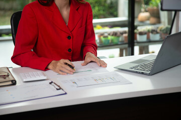 Businesswoman searching through laptop for online real estate on office desk