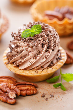 Delicious mini tarts with whipped cream and pecans. Close up.