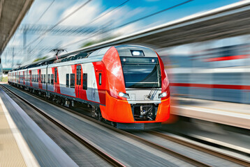 Fototapeta premium Modern high-speed train moves fast along the platform.